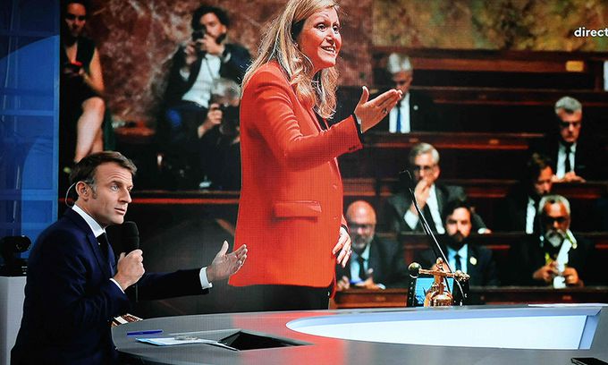 올림픽 핑계로… 에마뉘엘 마크롱 프랑스 대통령(왼쪽)이 23일(현지시간) 파리 트로카데로에 위치한 인류 박물관 옥상 세트장에서 프랑스2방송과 인터뷰하고 있다. 마크롱 대통령 뒤에 설치된 대형 스크린에는 지난 18일 총선에서 재선에 성공한 집권여당 르네상스의 야엘 브룬 피베 하원의장의 모습이 보인다. 파리=AFP연합뉴스