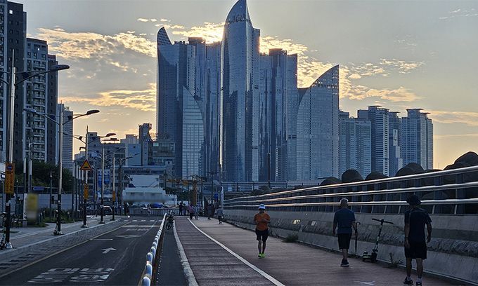 14일 시민들이 더위를 피해 이른 아침 부산 수영구 민락수변로를 걷고 있다. 연합뉴스