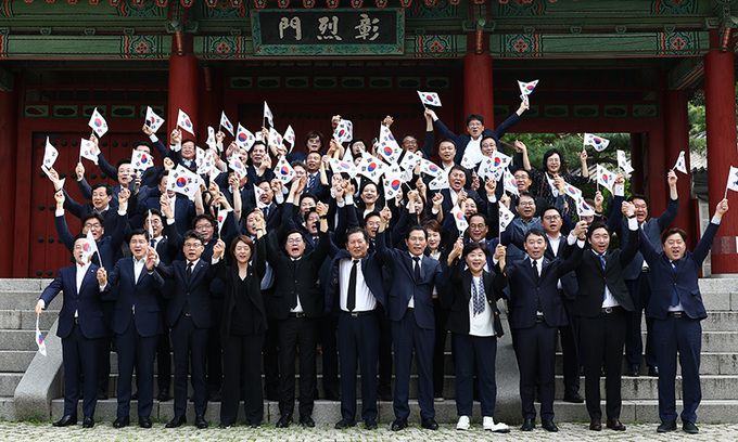 박찬대 더불어민주당 대표 직무대행 겸 원내대표를 비롯한 지도부가 제79주년 광복절인 15일 서울 용산구 효창공원에서 임정요인(이동녕·조성환·차리석) 묘역 참배에 앞서 태극기를 들고 만세삼창을 하고 있다. 뉴스1
