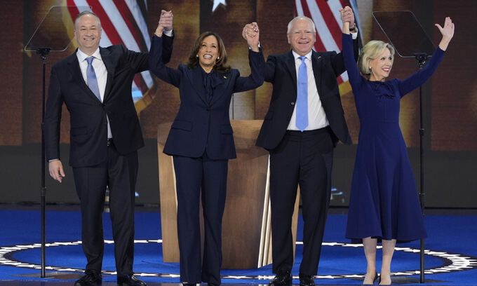 미국 민주당 대선 후보 카멀라 해리스(왼쪽 두 번째) 부통령이 22일(현지시각) 일리노이주 시카고의 유나이티드 센터에서 열린 민주당 전당대회(DNC)에서 대통령 후보 수락 연설을 마친 후 남편인 더그 엠호프(왼쪽), 부통령 후보인 팀 월즈 미네소타 주지사, 그의 부인 그웬과 함께 인사하고 있다. AP뉴시스