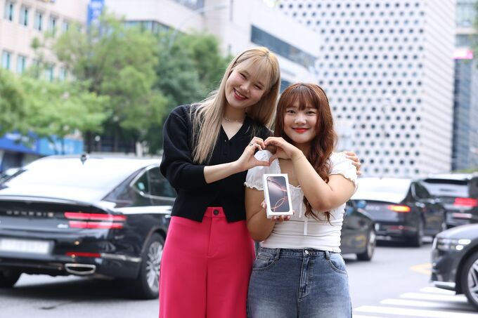 방송인 엄지윤이 유플러스닷컴 사전예약 고객인 김민선씨에게 '아침배송'으로 아이폰16 프로를 전달하는 모습. LG유플러스 제공