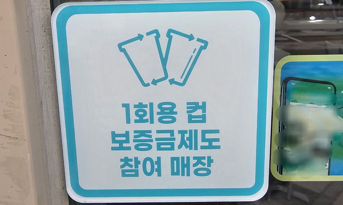 세종시의 한 커피숍 문에 부착돼 있는 일회용컵 보증금제 안내문. 세종=강은선 기자