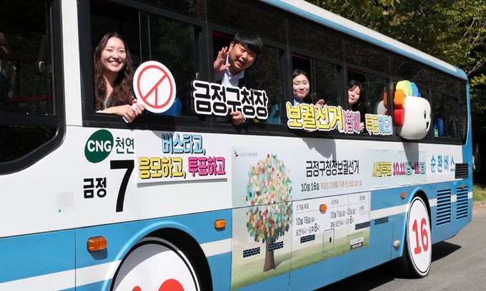 지난 9월 30일 부산 금정구 부산대학교 경암체육관 앞에서 부산시선관위 직원들과 부산대 학생들이 마을버스를 활용해 10·16 부산 금정구청장 보궐선거 투표 참여를 독려하는 캠페인을 하고 있다. 뉴스1
