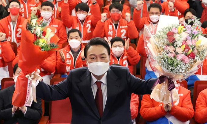 제20대 대통령 당선인이 지난 2022년 3월10일 서울 여의도 국회도서관에 마련된 국민의힘 제20대 대통령선거 개표상황실에서 꽃다발을 들고 있다. 공동취재사진