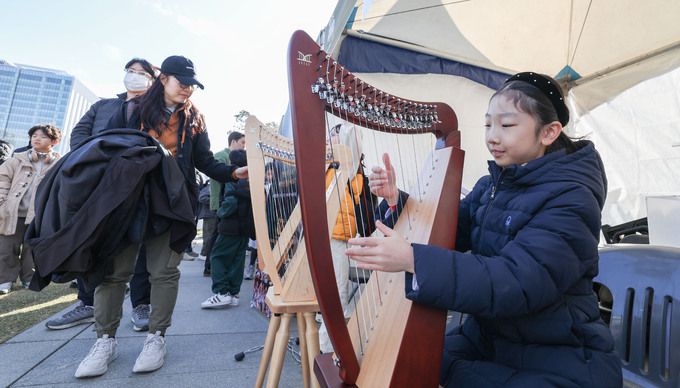 17일 서울 종로구 광화문광장에서 열린 제2회 전국학생문화경진대회에서 한 아이가 미니 하프를 연주해보고 있다.