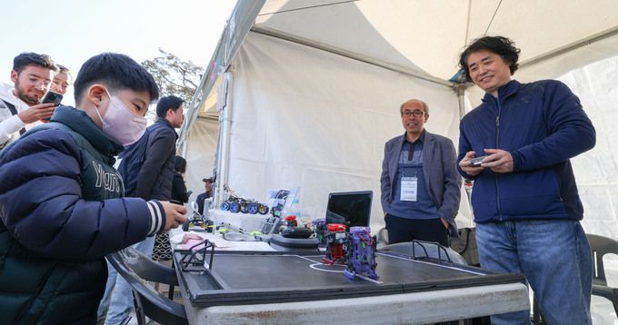 17일 서울 종로구 광화문광장에서 열린 제2회 전국학생문화경진대회에서 아버지와 아들이 로봇 축구를 하고 있다.