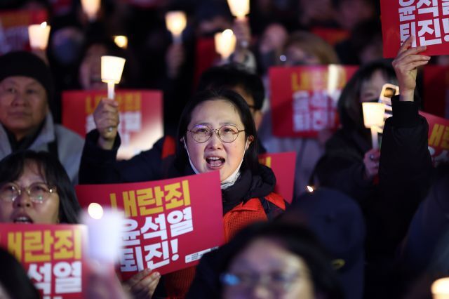 4일 오후 서울 동화면세점 앞에서 전국민주노동조합총연맹 주최로 열린 ‘내란죄 윤석열 퇴진! 시민촛불’에서 참가자들이 촛불을 들고 있다. 연합뉴스