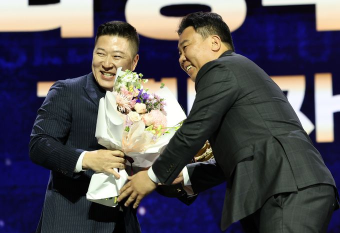 KIA 타이거즈 최형우가 13일 서울 강남구 코엑스 오디토리움에서 열린 2024 KBO 골든글러브 시상식에서 지명타자부문 골든글러브를 수상하자 이범호 감독이 꽃다발을 전하고 있다. 뉴시스