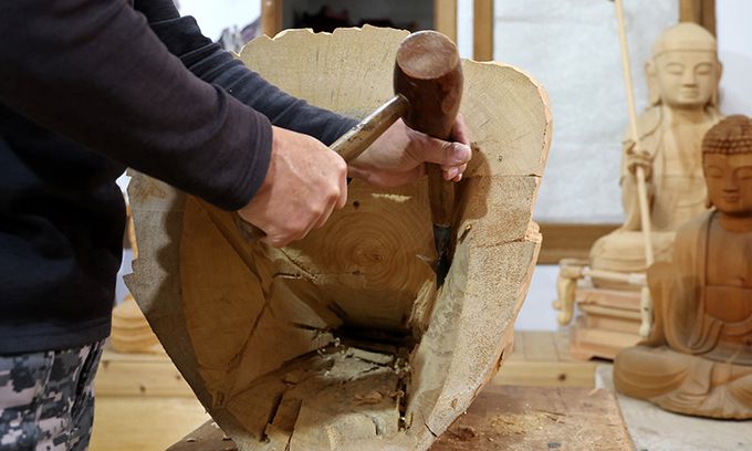 목불상의 갈라짐을 방지하고 복장 유물 공간 확보를 위해 나무의 속을 비우고 있다.