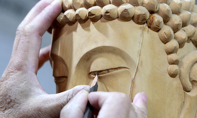 완성된 부처의 눈을 그려 넣는 마지막 작업에 집중하고 있다.