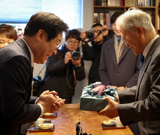 이재명 더불어민주당 대표(왼쪽)가 30일 오후 경남 양산시 하북면 평산마을 문재인 전 대통령 사저를 방문해 문 전 대통령에게 선물을 전달하고 있다.    더불어민주당 제공