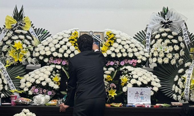 지난 12일 대전 서구 한 초등학교에서 40대 교사에게 살해된 김하늘양의 아버지가 건양대병원 장례식장에 마련된 빈소에서 하늘양의 영정사진을 어루만지고 있다. 뉴스1