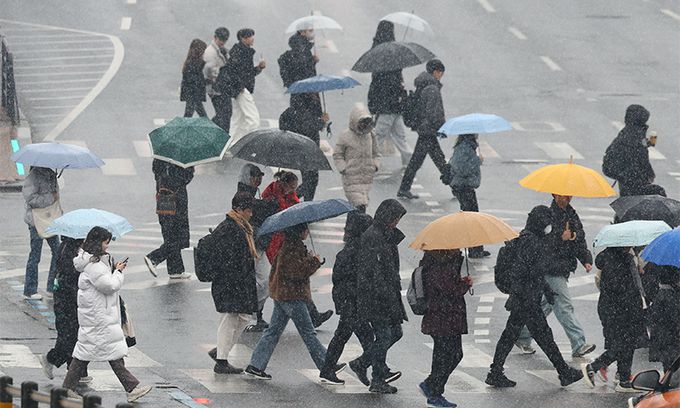 지난 12일 서울 서대문구 성산로에서 우산을 쓴 시민들이 발걸음을 재촉하고 있다. 뉴시스