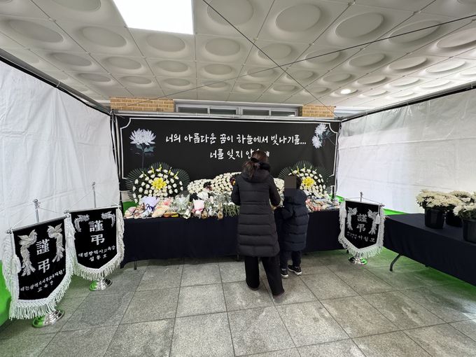 14일 대전 서구의 한 초등학교에 설치된 하늘양 시민합동분향소를 찾은 학부모와 자녀가 추모하고 있다.