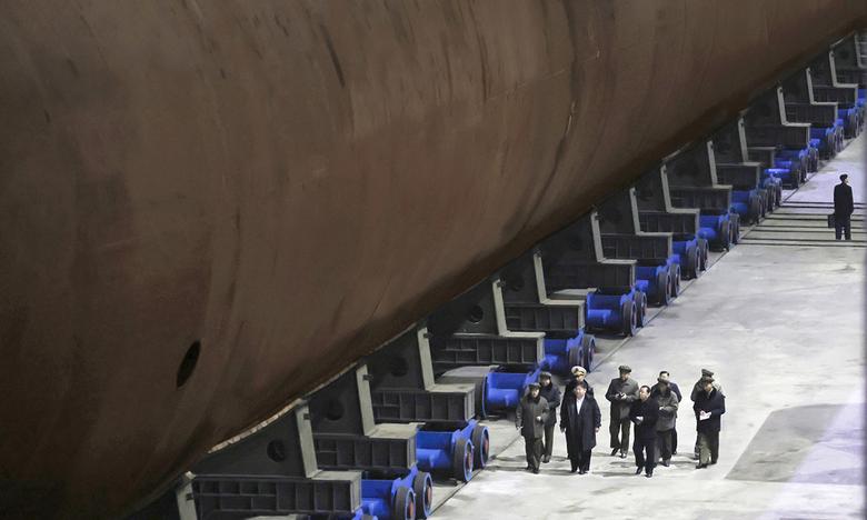 건조상태 미흡?… 선체 하부만 공개 김정은 북한 국무위원장(앞 줄 왼쪽에서 두 번째)이 핵추진 잠수함으로 추정되는 함정의 옆을 수행원들의 설명을 들으며 이동하고 있다. 북한 조선중앙통신은 8일 김 위원장이 함선건조 사업을 현지지도하고, 핵추진 잠수함의 건조 실태를 시찰했다고 보도했다. 조선중앙통신·연합뉴스