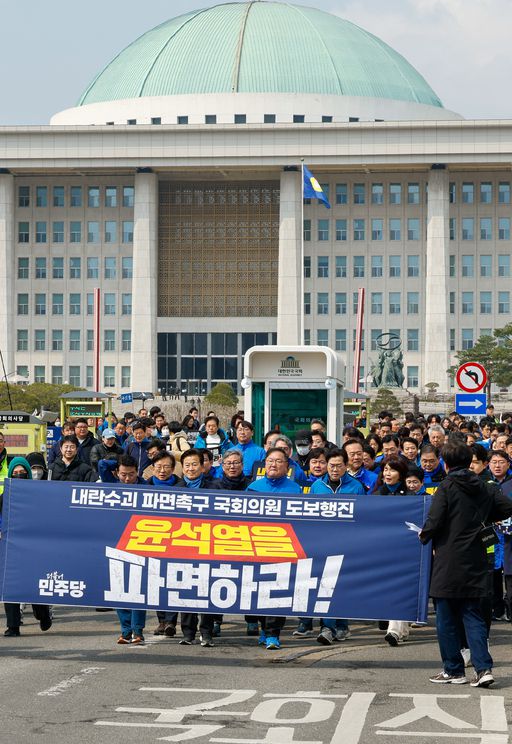 더불어민주당 의원들이 16일 서울 여의도 국회에서 ‘대통령 파면촉구 국회의원 도보행진’을 하며 광화문으로 향하고 있다. 뉴스1