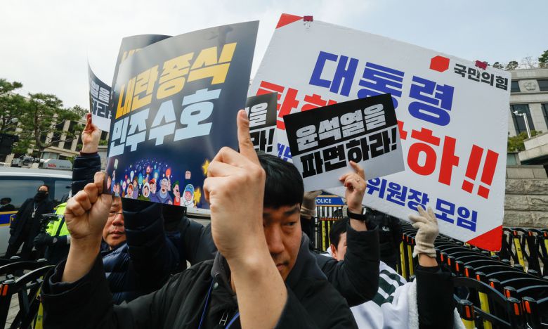 거칠어진 탄핵 찬반시위 더불어민주당 의원들이 20일 서울 종로구 헌법재판소 앞에서 윤석열 대통령의 신속 파면을 촉구하는 기자회견을 연 가운데 민주당 관계자들이 ‘윤석열을 파면하라’고 적힌 피켓으로 국민의힘 관계자들이 들고 있는 ‘대통령 탄핵 각하’ 피켓을 가리고 있다. 민주당 백혜련 의원과 이건태 의원은 이날 오전 회견 도중 건너편 인도에서 날아온 날계란을 맞았다. 최상수 기자