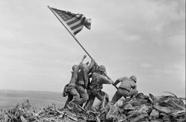 2차대전 도중인 1945년 2월 일본 섬 이오지마에 상륙한 미국 해병대원 6명이 섬에서 가장 높은 수리바치 산 정상에 대형 성조기를 게양하고 있다. AP연합뉴스