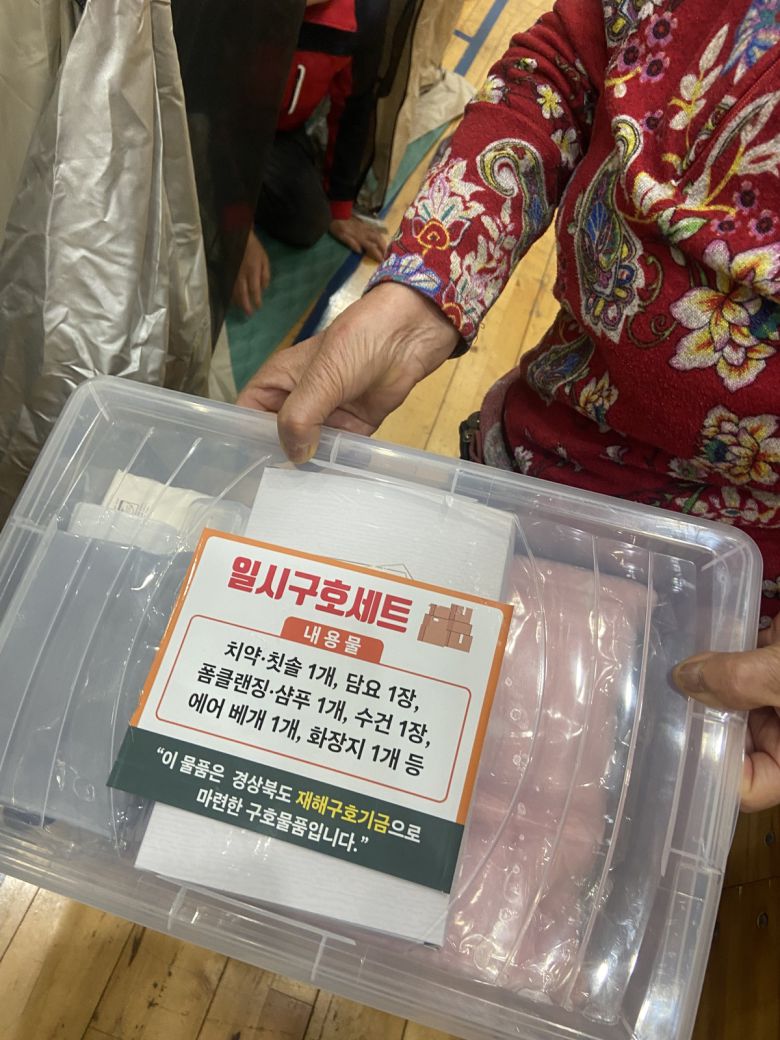 경북 의성군 산불 이재민을 위한 임시대피소가 차려진 의성체육관에서 만난 주민이 구호 세트를 직접 보여주고 있다.