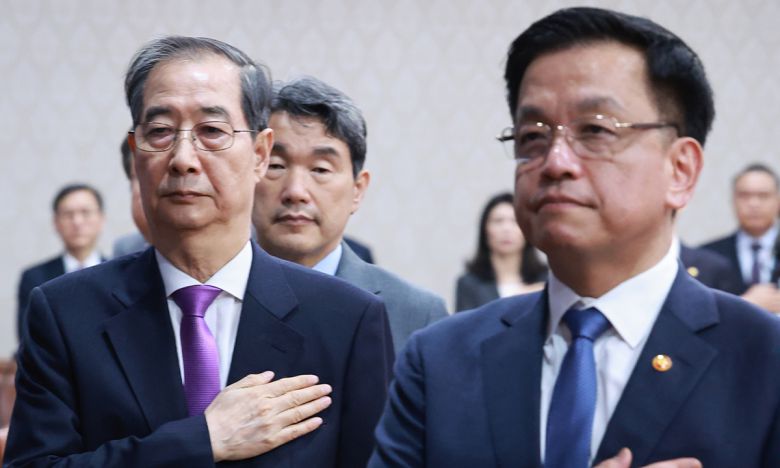 한덕수 대통령 권한대행 국무총리와 최상목 경제부총리 겸 기획재정부 장관이 25일 정부서울청사에서 열린 국무회의에서 국기에 경례를 하고 있다. 연합뉴스