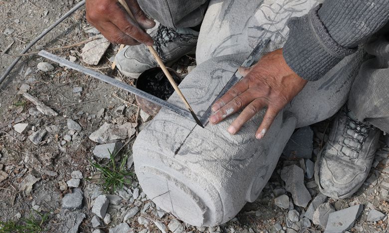 축소 재현 조성 중인 미륵불 부처에 고석산 석장이 자로 크기를 표시하고 있다.