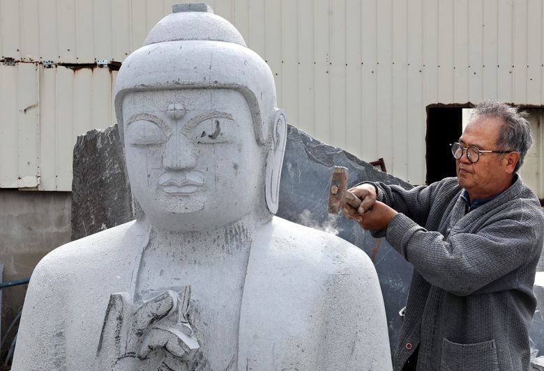 약사여래불 조성 중인 고석산 석장이 도드락망치질을 하며 표면을 고르고 있다.