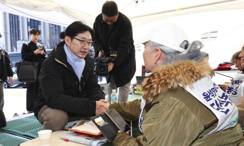 단식 농성 중인 김경수(왼쪽) 전 경남지사가 지난 3월 28일 서울 종로구 광화문 광장 인근 비상행동 천막 농성장에서 병원 퇴원을 마치고 인사를 하고 있다. 뉴시스