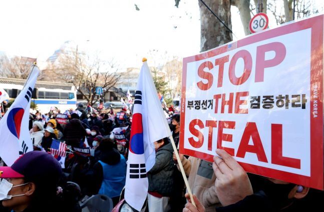 윤석열 전 대통령 지지자들이 지난 2월23일 서울 종로구 헌법재판소 인근에서 부정선거 의혹을 제기하며 팻말을 들고 있다. 연합뉴스