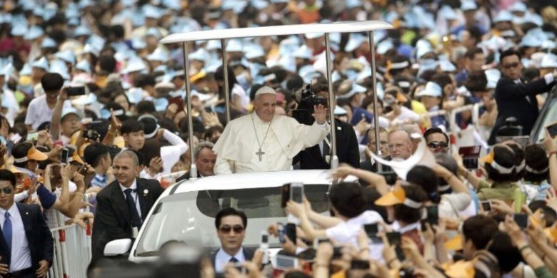 프란치스코 교황(가운데)이 2014년 8월16일 서울 광화문광장에서 열린 미사를 집전하기 위해 도착하면서 가톨릭 신자들의 환영을 받고 있다. AFP연합뉴스