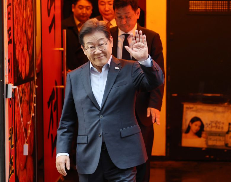 이재명 더불어민주당 대통령 후보가 1일 서울 종로구의 한 포차 식당에서 '당신의 하루를 만드는, 보이지 않는 영웅들'이란 주제로 열린 배달 라이더, 택배 기사 등 비(非)전형 노동자들과 간담회를 마친 뒤 나서며 손인사를 하고 있다.    공동취재