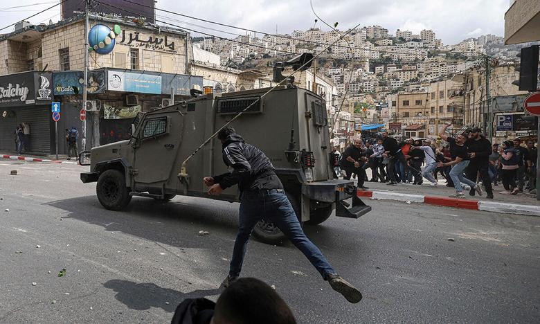 팔레스타인인들, 이스라엘 장갑차에 돌 투척 가자지구에 대한 지상전 추가 확대로 이스라엘군에 대한 팔레스타인인들의 반감이 더 확산하고 있는 가운데 4일(현지시간) 요르단강 서안 도시 나블루스에서 주민들이 이스라엘군의 장갑차에 돌을 던지고 있다. 나블루스=AFP연합뉴스