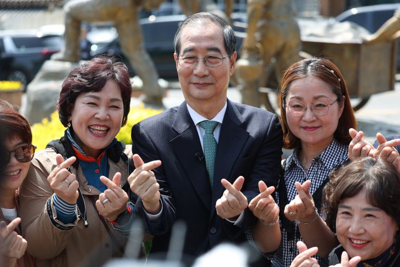 지지자들과 기념 촬영 무소속 한덕수 대선 예비후보(가운데)가 8일 경북 구미의 박정희 전 대통령 생가를 찾아 지지자들과 함께 손가락 하트를 만들며 기념 사진을 찍고 있다.   구미=뉴시스