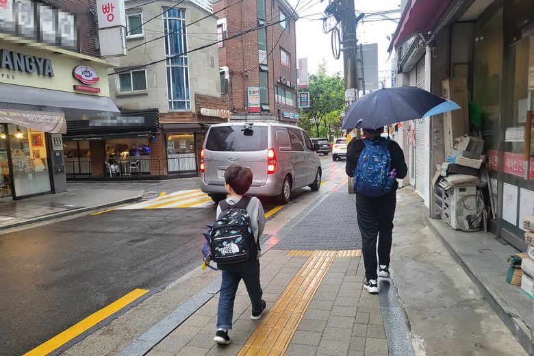 서울의 한 주거지에서 아이와 보호자 하교길 전경. ‘누가 아이와 함께 걸어줄 수 있느냐’가 집을 정하는 기준이 됐다.