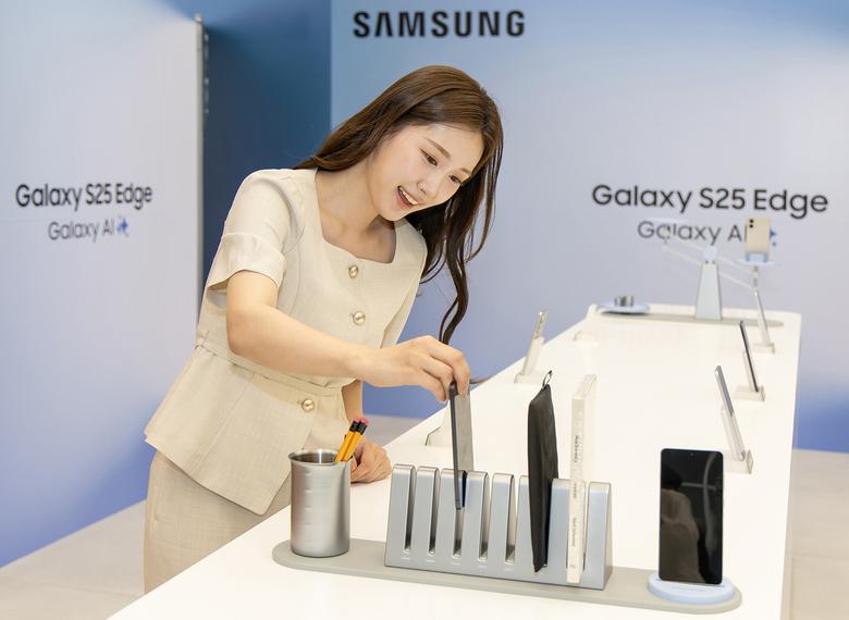 모델이 삼성전자의 초슬림 스마트폰 ‘갤럭시 S25 엣지’를 폭이 좁은 책꽃이에 꽃아보고 있다.    삼성전자 제공