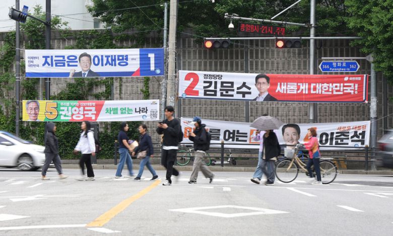 15일 경기 의정부시의 한 교차로에서 길을 건너는 시민들 뒤로 제21대 대통령 선거 후보들의 현수막이 걸려 있다. 의정부=연합뉴스