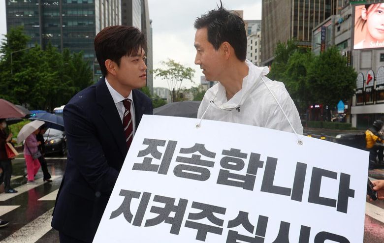 국민의힘 김용태 비상대책위원장(왼쪽)이 16일 서울 종로구 세종대로사거리를 찾아 지지호소 피켓팅을 하고 있는 김기흥 전 대통령실 부대변인을 격려하고 있다. 연합뉴스