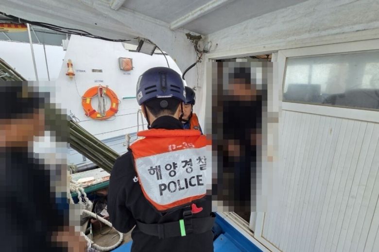 4건 혐의로 지명수배 중이던 40대가 운항하던 어선에서 해경이 신원 확인을 하고 있다. 군산해경 제공