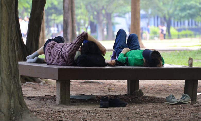 지난 21일 서울 성동구 서울숲에서 시민들이 그늘에서 휴식을 취하고 있다. 연합뉴스