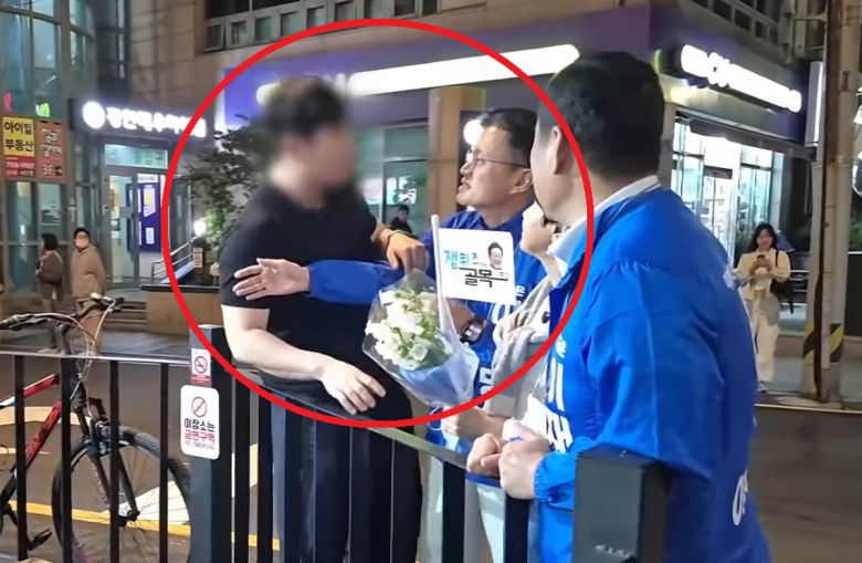 지난 23일 부산에서 더불어민주당 이재명 대선 후보 지원 유세를 하던 같은당 박주민 의원을 붙잡고 질문 중인 남성. 박주민TV 유튜브 캡처