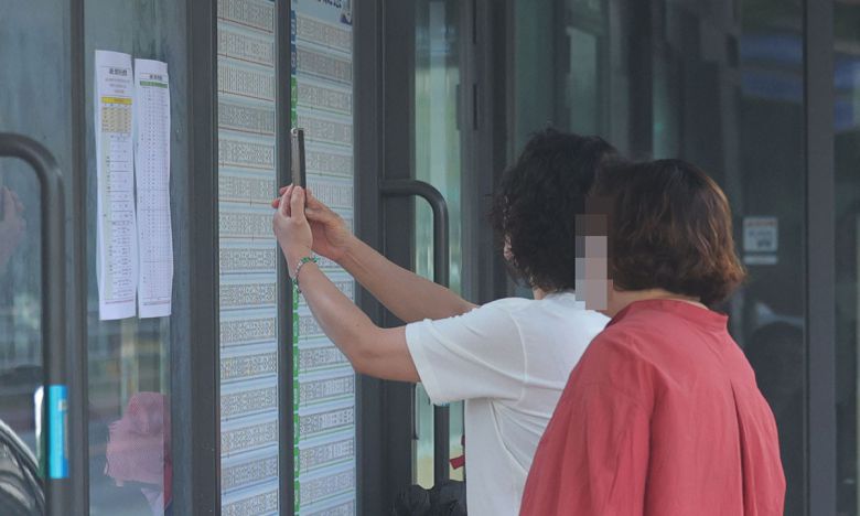 경남 창원지역 시내버스가 파업에 돌입한 28일 창원 성산구 시민생활체육관 정류장에서 시민들이 임시 버스 시간표를 들여다보고 있다. 연합뉴스