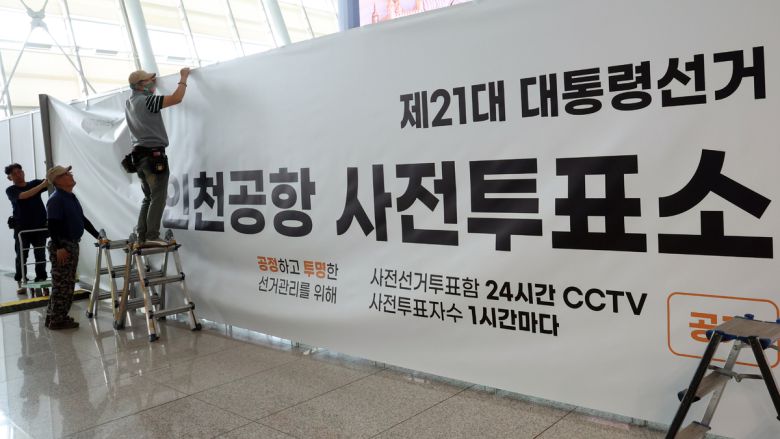 출국 전 사전투표 하세요 21대 대통령선거 사전투표를 이틀 앞둔 27일 인천선거관리위원회 직원들이 인천국제공항 출국장에서 사전투표소를 안내하는 대형 현수막을 설치하고 있다. 사전투표는 29∼30일 진행된다. 인천공항=뉴스1