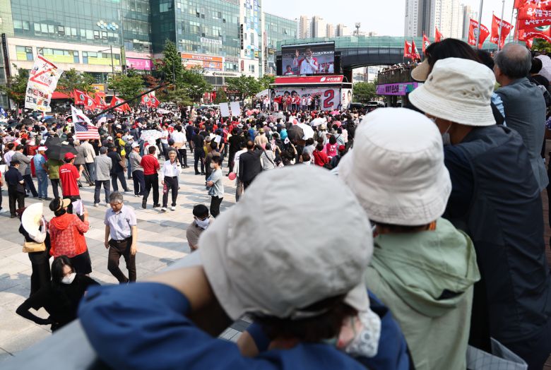 김문수 국민의힘 대선 후보가 29일 경기 안산시 안산문화광장에서 열린 유세에서 지지호소를 하고 있는 가운데 시민들이 지켜보고 있다.   공동취재