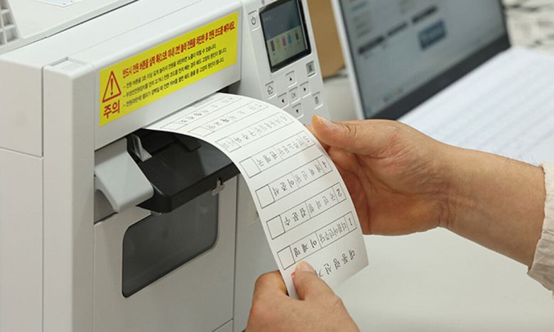 한 사전투표소에서 선관위 관계자가 투표용지를 인쇄하고 있다. 연합뉴스