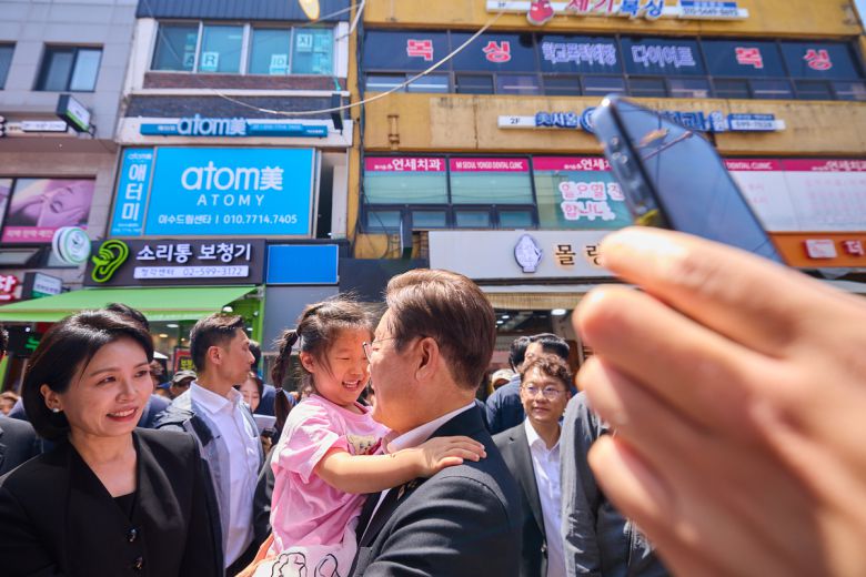 이재명 대통령과 김혜경 여사가 6일 서울 동작구 남성시장을 방문해 한 아이를 안아주고 있다. 대통령실 제공