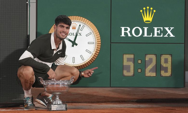 카를로스 알카라스가 9일 프랑스 오픈 남자 단식 결승에서 역대 최장인 5시간29분 혈투 끝에 우승한 뒤 게임 시간을 알리는 시계를 가리키며 기념촬영을 하고 있다. 파리=AP연합뉴스