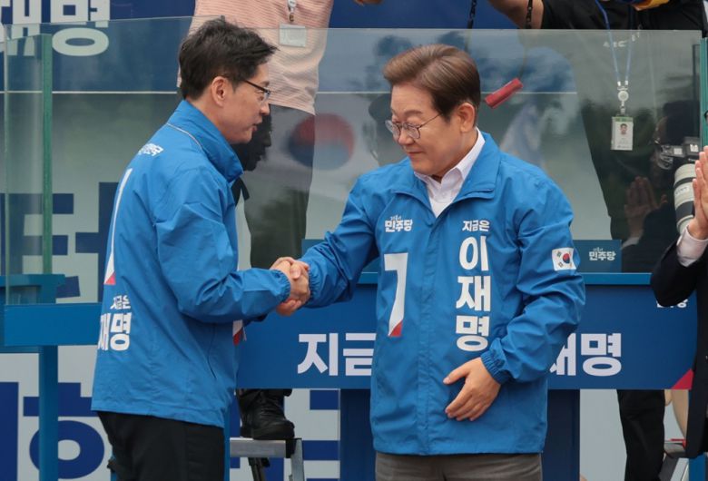 제21대 대통령선거 공식 선거운동 당시 더불어민주당 이재명 대선 후보가 지난달 22일 경남 양산시 양산워터파크공원에서 열린 집중 유세에서 김경수 총괄선대위원장과 악수하고 있다. 공동취재