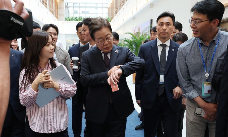 이재명 대통령이 10일 서울 용산 대통령실 청사에서 시계를 보며 이동하고 있다. 이 대통령은 이날 직원 식당에서 참모들과 점심 식사를 한 뒤 마주친 출입기자과 셀카를 찍기도 했다. 연합뉴스