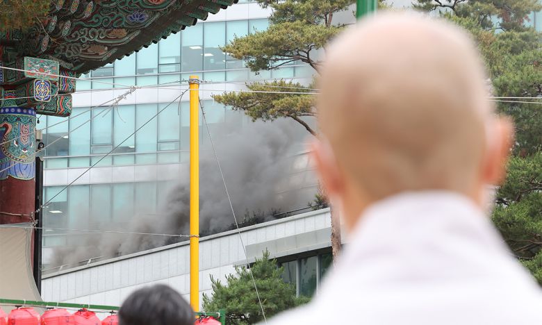 10일 서울 종로구 조계사 옆 한국불교역사문화기념관 국제회의장에서 화재가 발생한 가운데 한 스님이 현장을 바라보고 있다. 연합뉴스