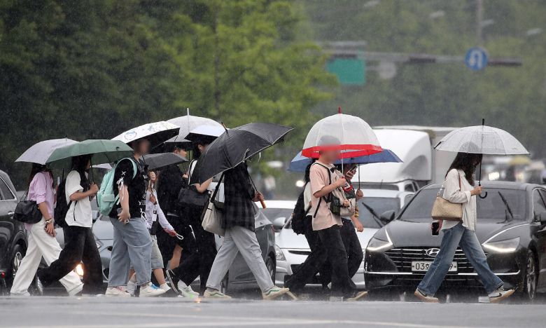 지난 13일 대구 달서구 계명대 성서캠퍼스 앞 도로에서 장맛비를 피해 우산을 쓴 시민들이 발걸음을 재촉하고 있다. 뉴스1