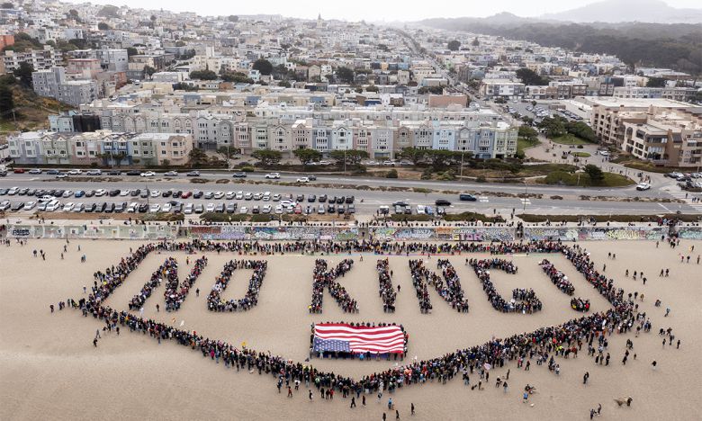 너무나 다른 두 풍경 14일(현지시간) 캘리포니아주 샌프란시스코에서 열린 ‘노 킹스’ 시위 중 참가자들이 ‘노 킹(NO KING)’이라는 인간 배너를 형성하고 있는 모습. 샌프란시스코=AP뉴시스